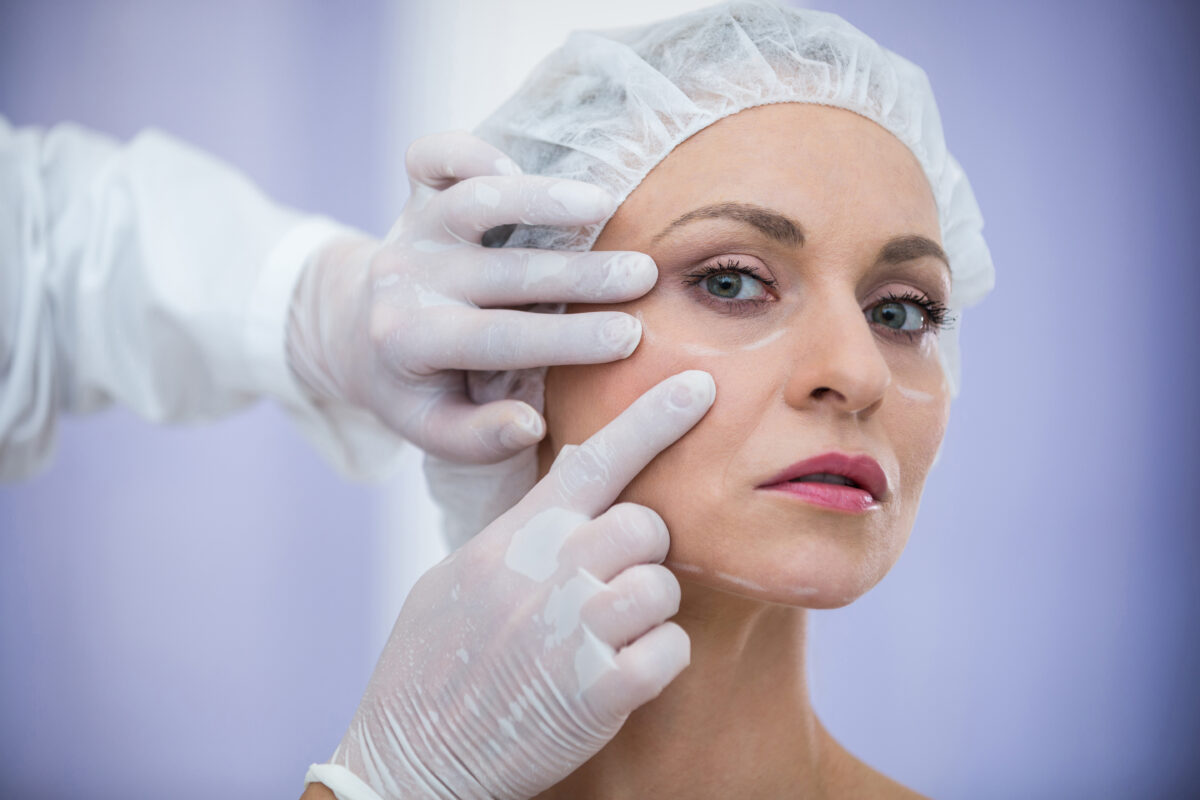 Cosmetic surgeon examining female patient’s face during consultation at top hospital in India