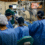 Doctors performing cornea transplant surgery in a modern operating room with advanced surgical equipment.