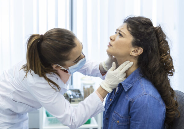 A doctor examining a woman’s neck for thyroid issues, representing diagnosis and treatment options like thyroid surgery in India.
