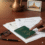 A person’s hand points to a green Ethiopian passport on a table, alongside Medical Visa application forms for India, a pair of glasses, a pen, and a framed photograph of an Indian monument—illustrating the process of obtaining a Medical Visa from Ethiopia to India.