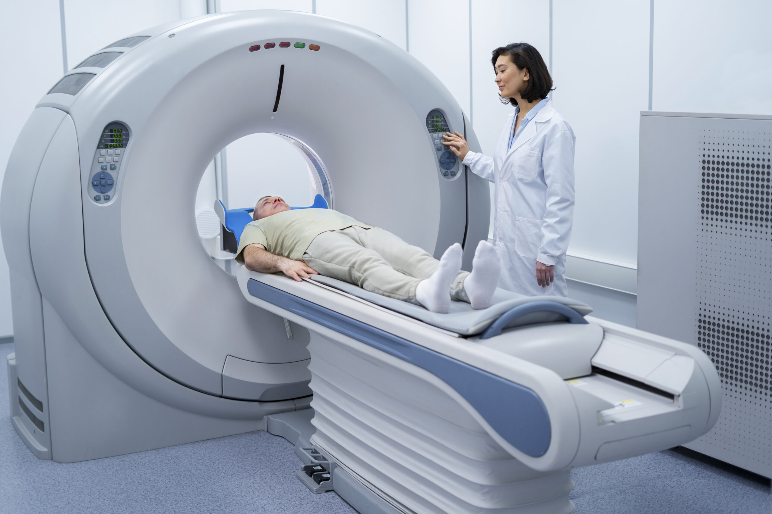A patient lies on a table entering a large, circular medical scanner while a doctor in a white lab coat operates the machine in a bright, modern radiology room—depicting stereotactic radiosurgery for brain tumors.