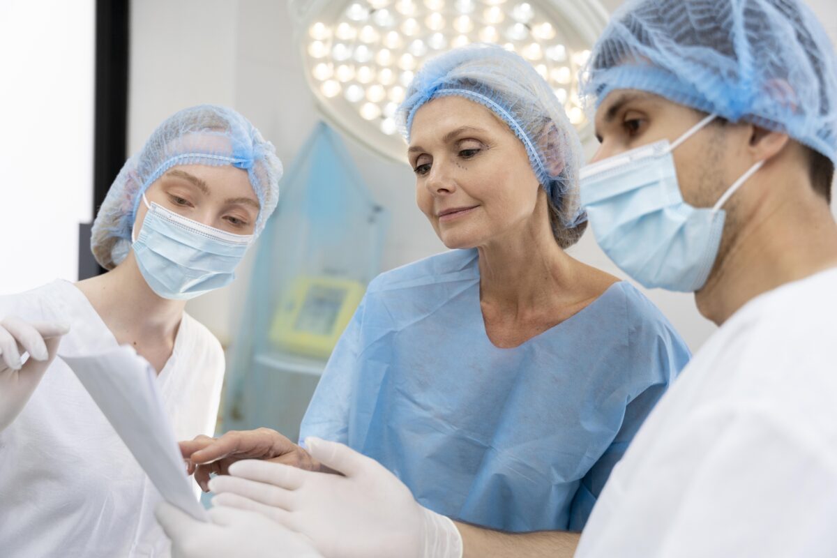 Breast cancer surgeons in India reviewing patient reports before surgery at a modern hospital.